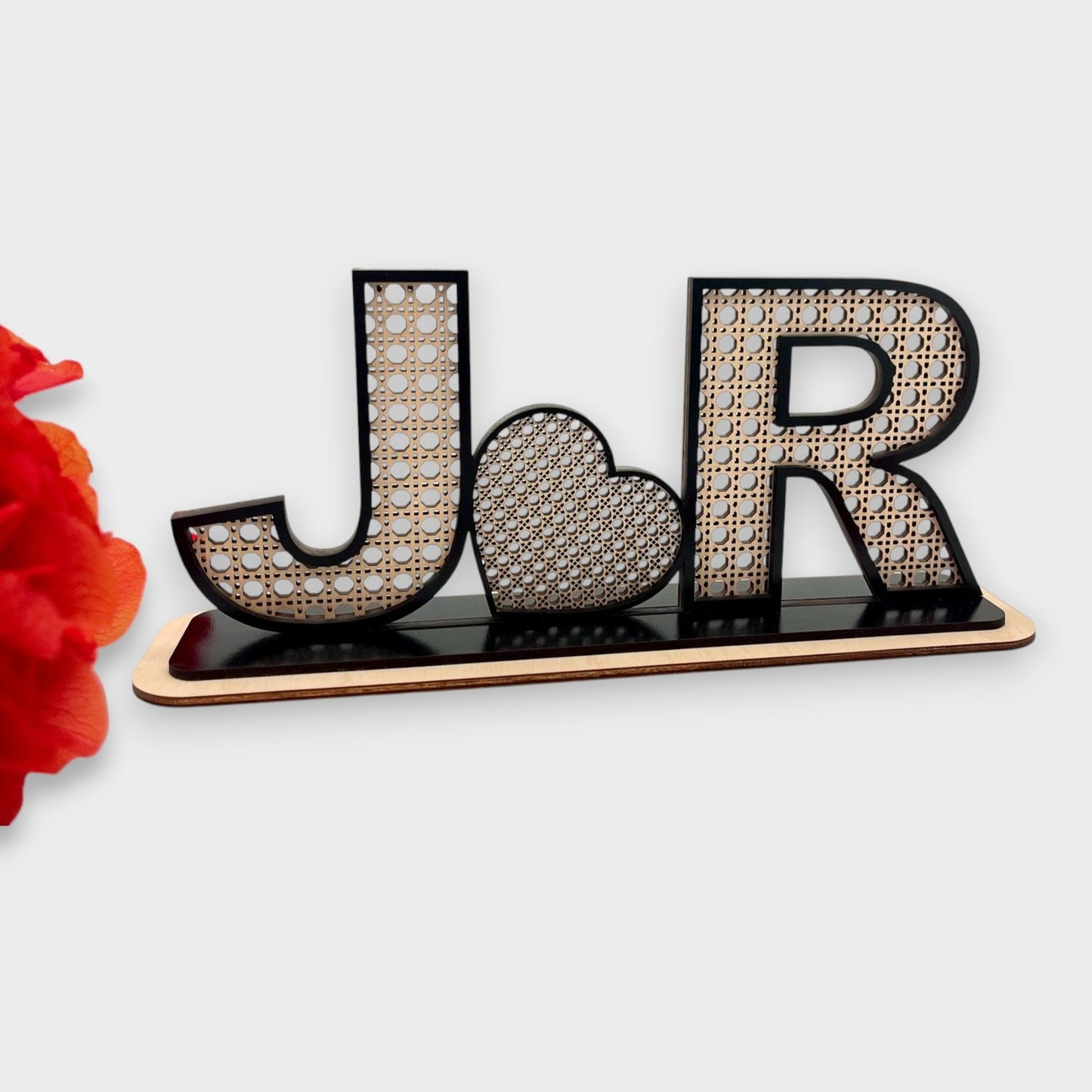 Base Rattan em bétula com contorno preto, personalizada com iniciais do casal com coração no meio.